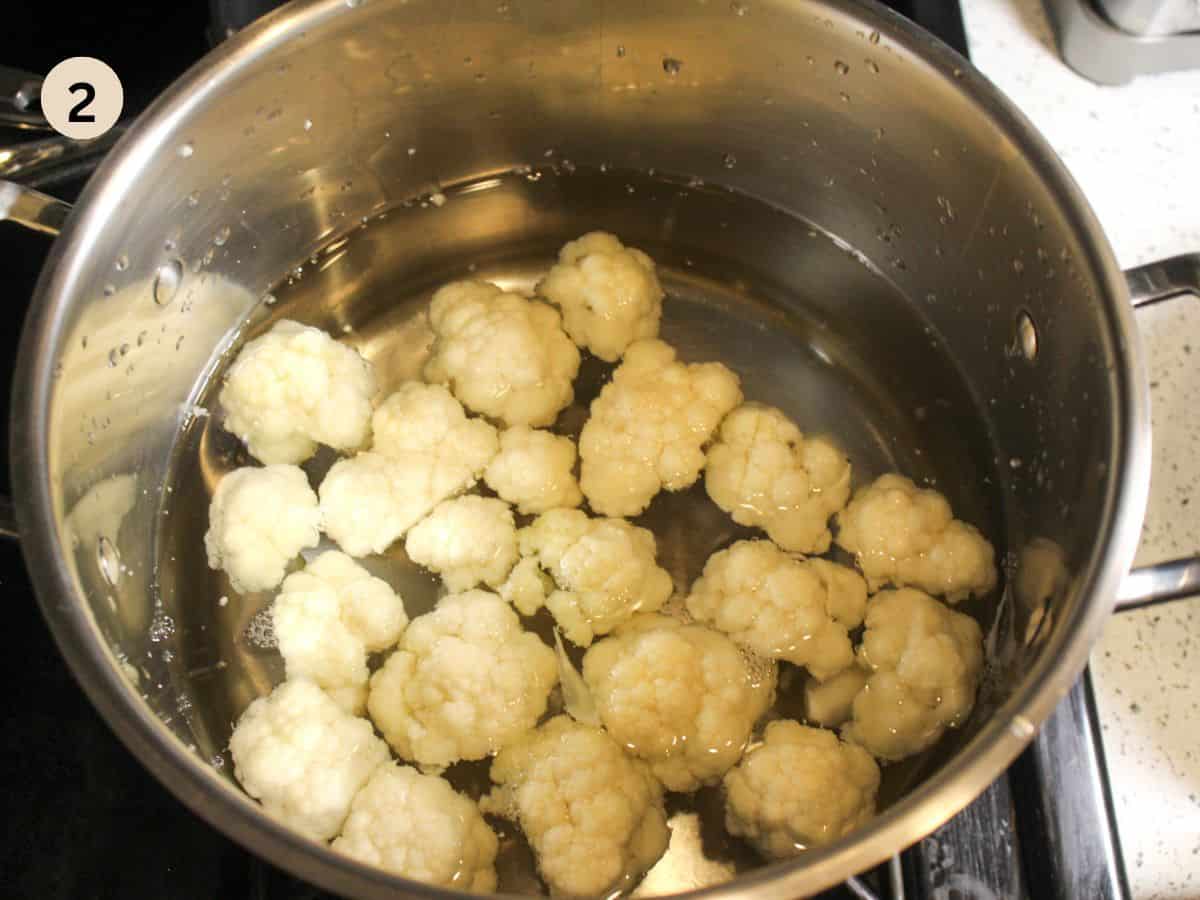 Parboiling cauliflower in a large pot.
