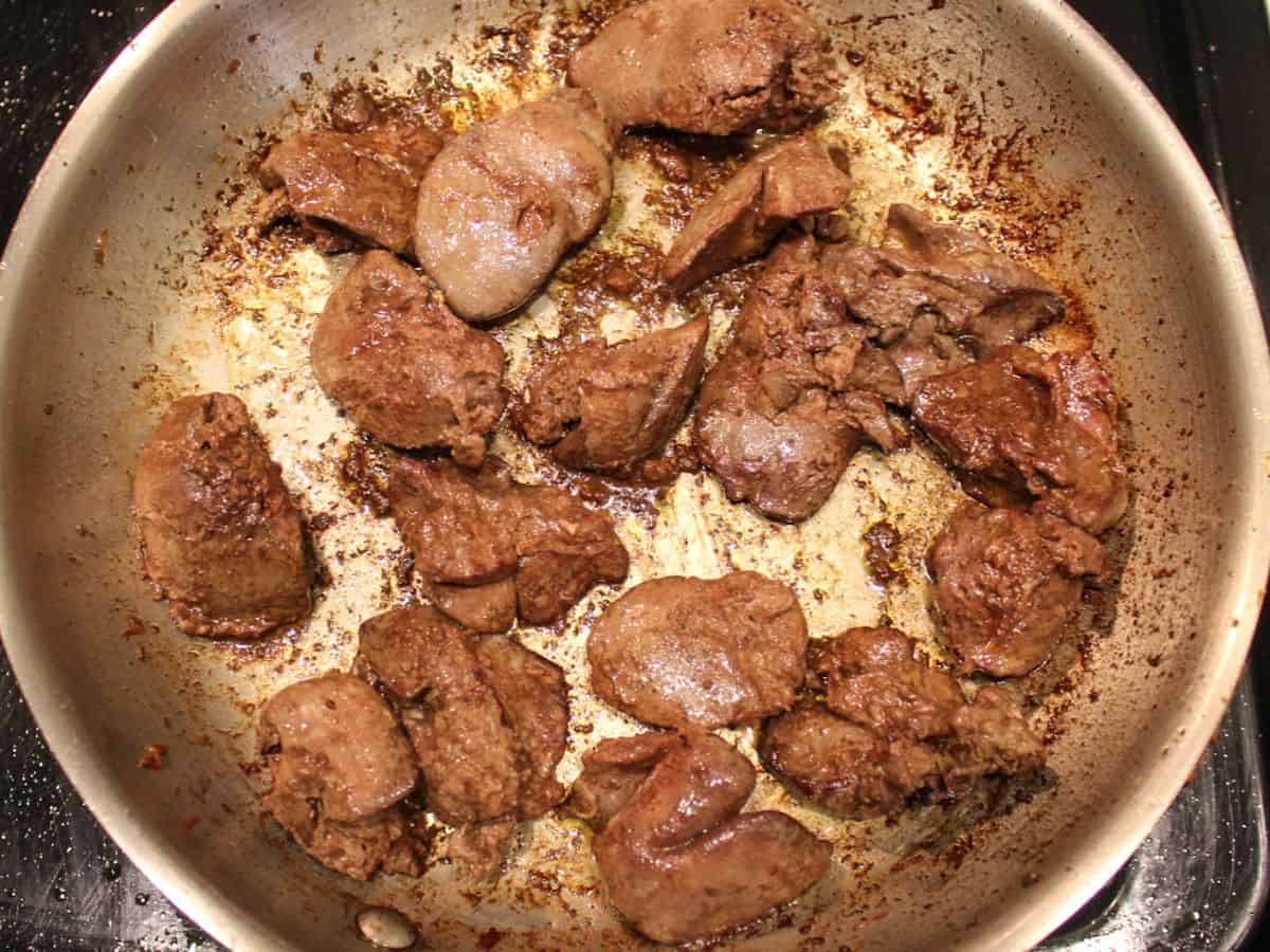 Seared chicken livers in a frying pan.