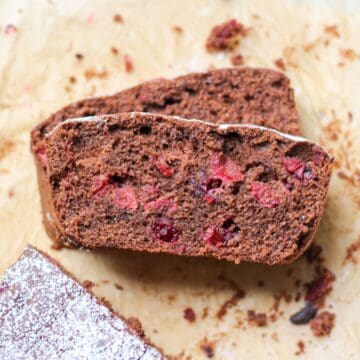 Chocolate cranberry load sliced on parchment paper with visible cranberries inside.