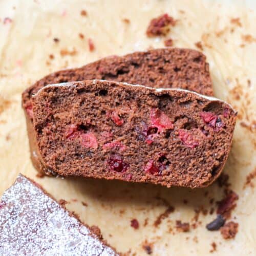 Chocolate cranberry load sliced on parchment paper with visible cranberries inside.