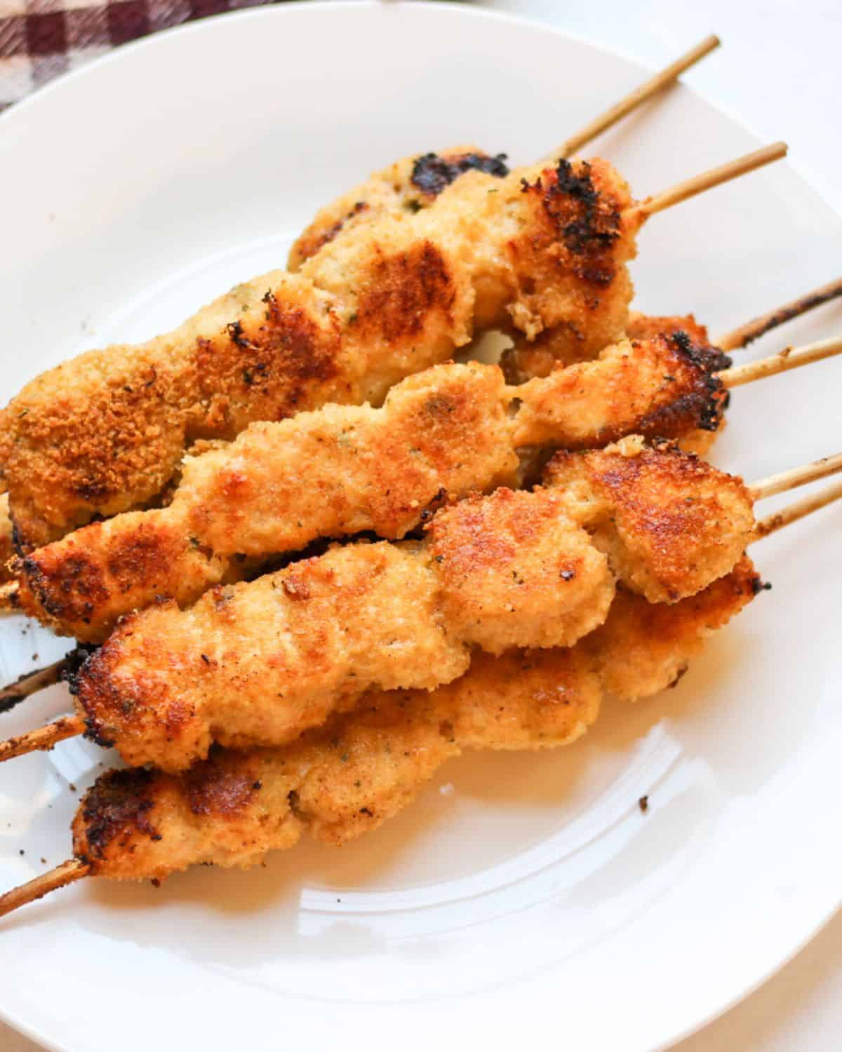 Crispy garlic Parmesan chicken skewers served on a plate. 