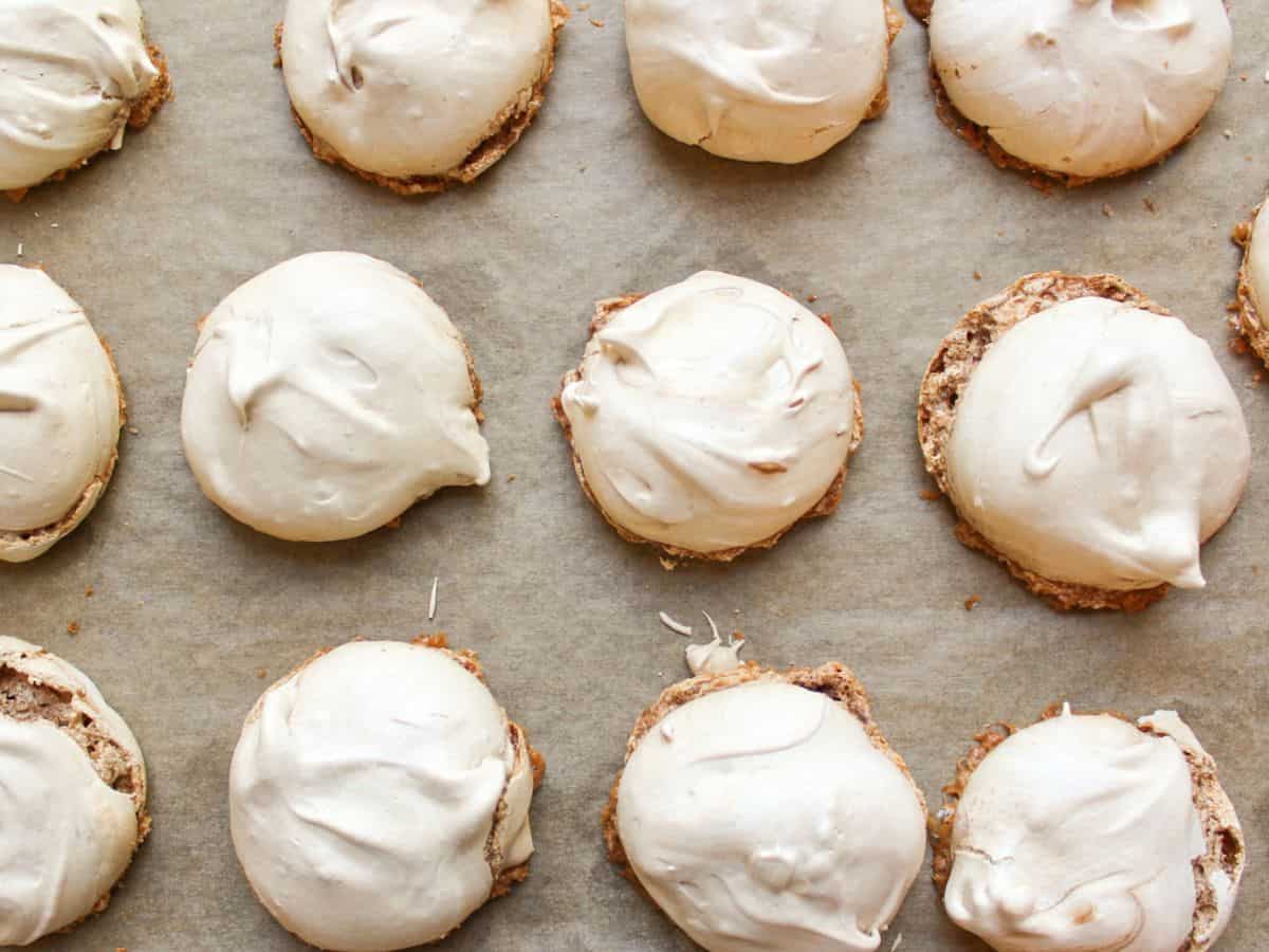 Baked chocolate meringue cookies on a baking pan lined with parchment paper. 