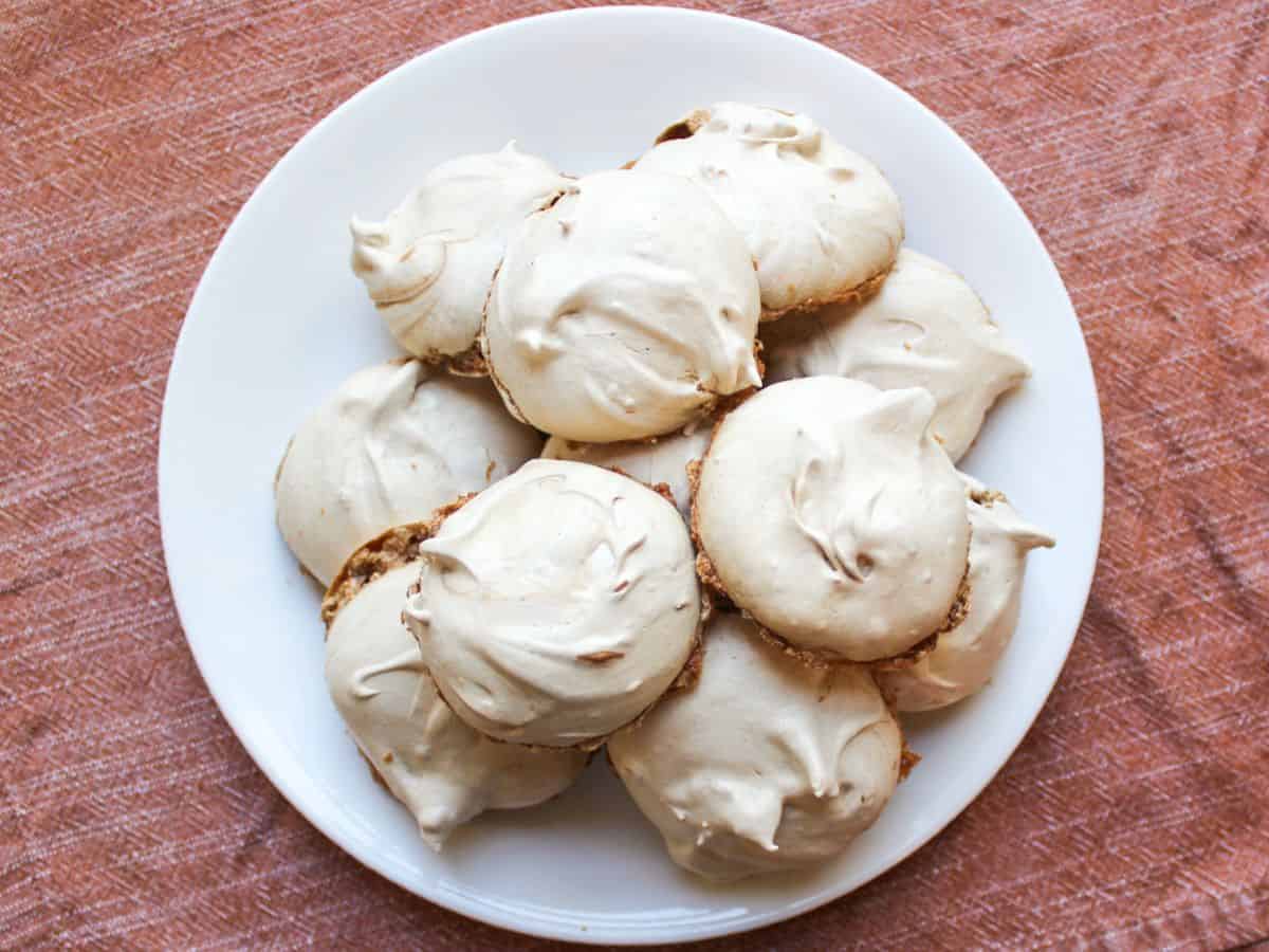 Light and airy chocolate meringue cookies piled up on a white plate.