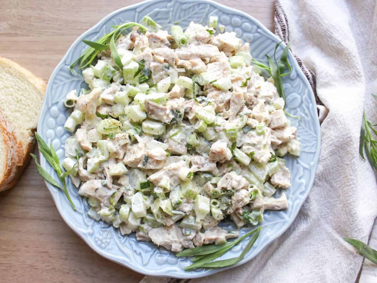 Classic chicken salad made with tender chicken, crisp celery, fresh herbs and creamy mayo dressing, served in a blue bowl. 