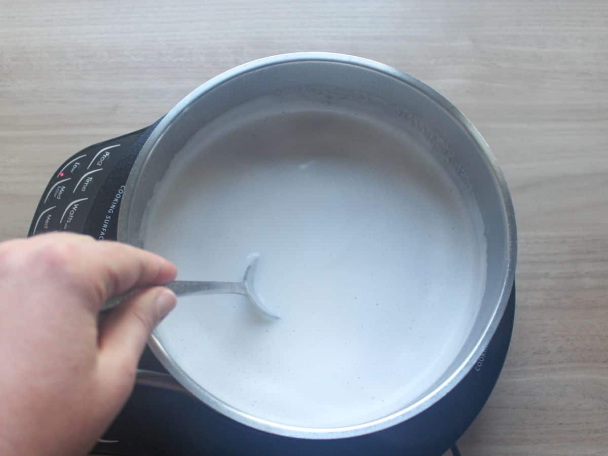 Cooking cream of buckwheat by stirring it in water and milk in a saucepan.