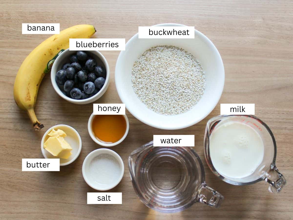 Ingredients for cream of buckwheat breakfast porridge, measured and labeled on a wooden countertop.