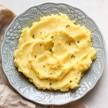 Creamy mashed potatoes served in a blue dinner plate.