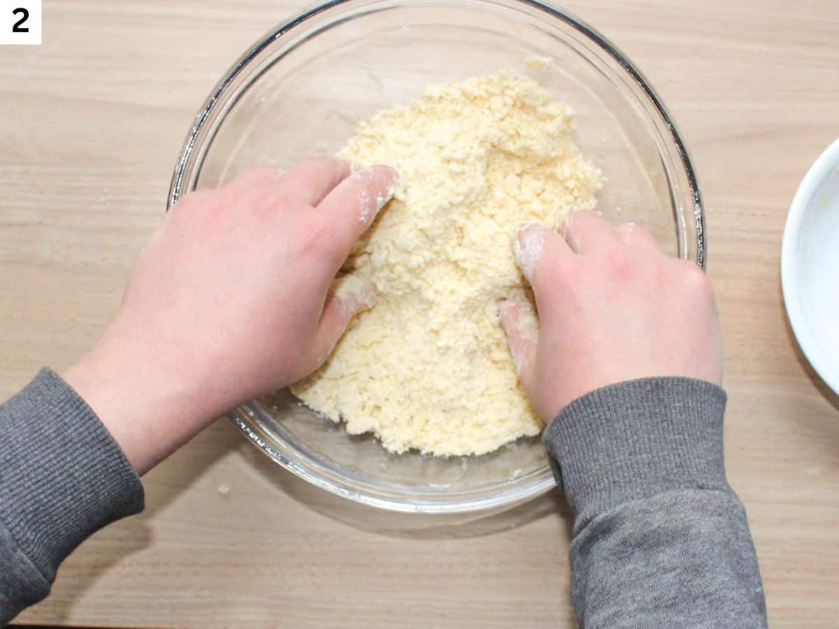 Rubbing the butter into thee flour until it looks like coarse crumb in a glass bowl 