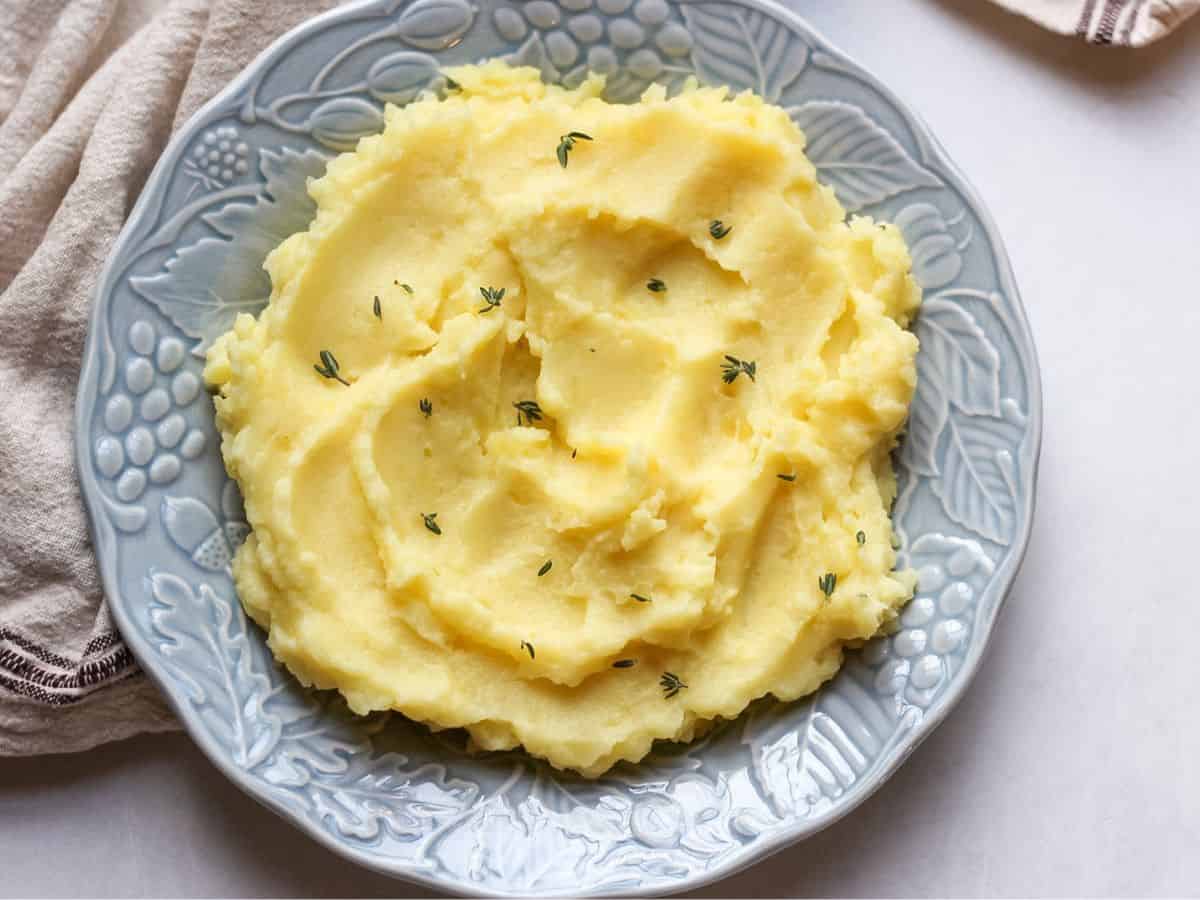 Creamy mashed potatoes served in a blue dinner plate. 