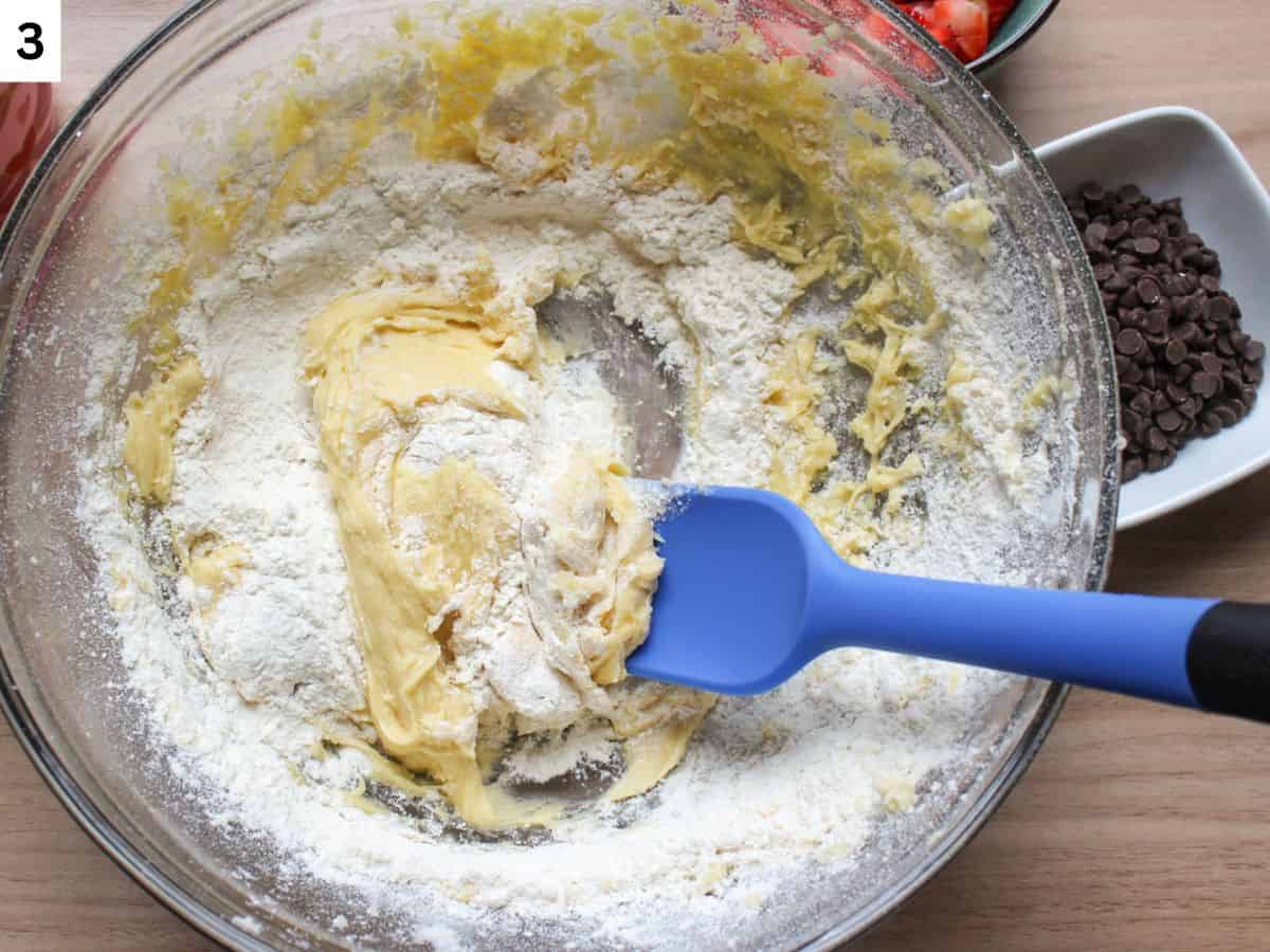 Mixing the rest of the flour using a silicone spatula.