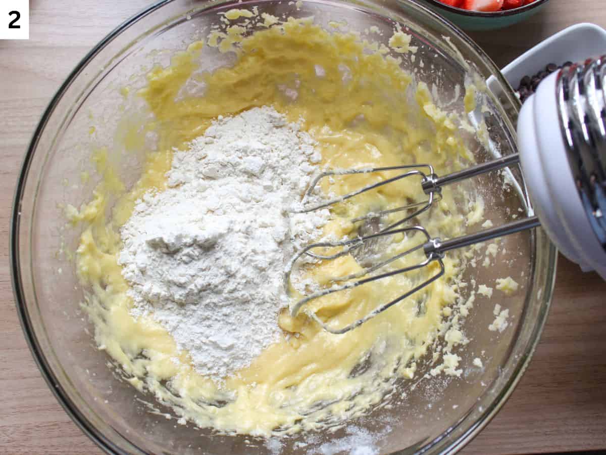 Adding half of the dry ingredients to the the wet ingredients in a glass bowl and mixing them with a mixer.