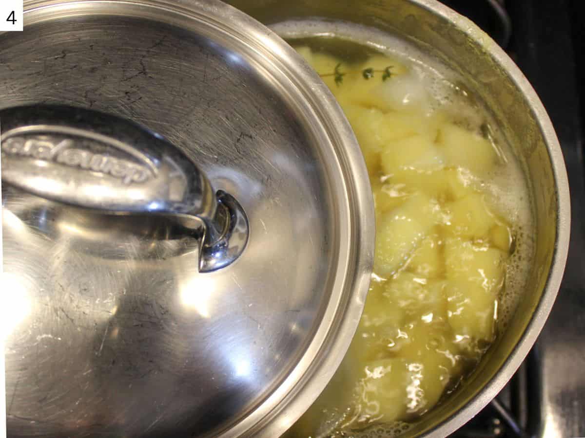 Potatoes are boiling in water in a pot, with the lid half open. 
