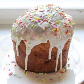 Traditional Ukrainian Easter Paska bread with white glaze and sprinkles on top.