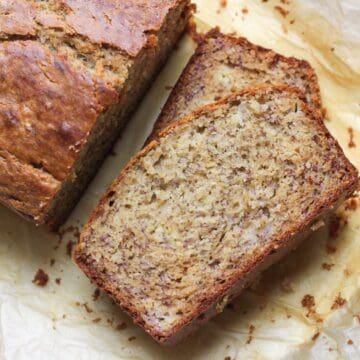 Overhead view of honey banana bread, with slices on parchment paper.