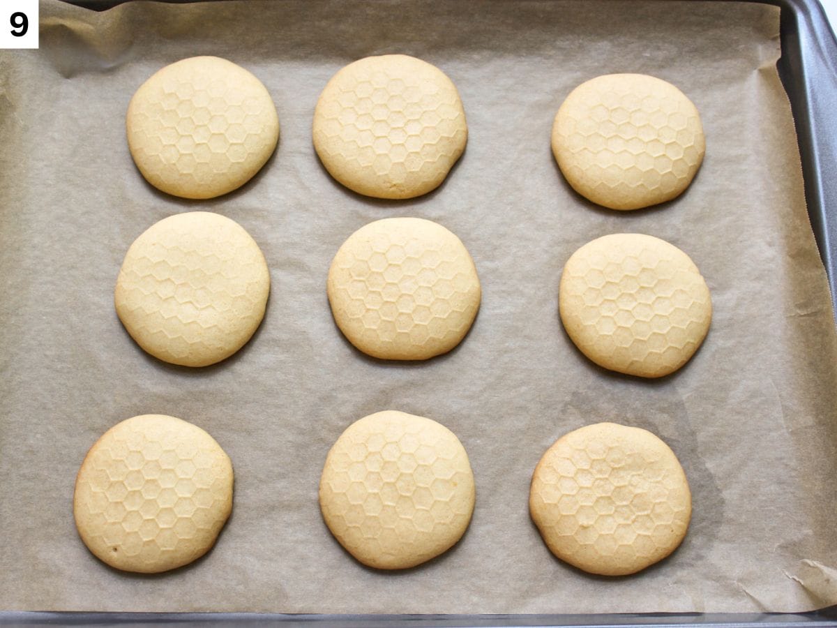 Baked soft honey cookies with golden brown edges on a baking pan. 