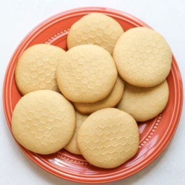 Soft homemade honey cookies with honeycomb pattern on an orange plate.
