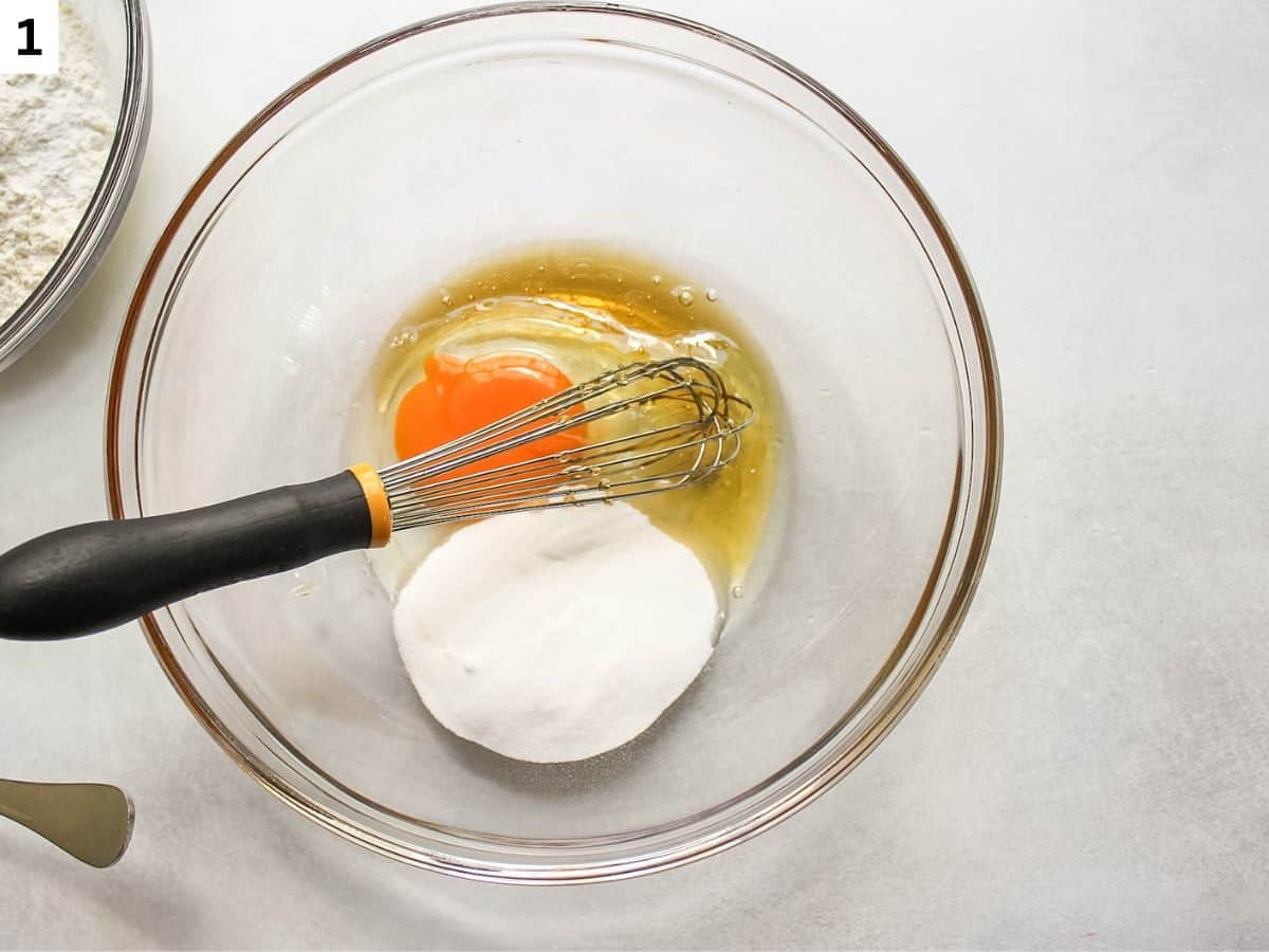 Sugar, honey and egg are added to the glass bowl. 