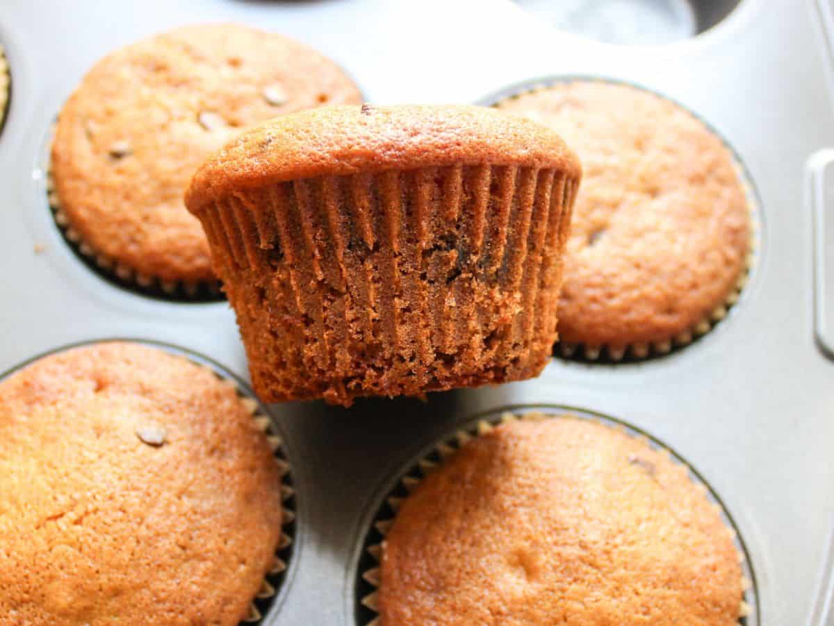Honey muffin laying sideways on a baking pan with the rest of muffins.