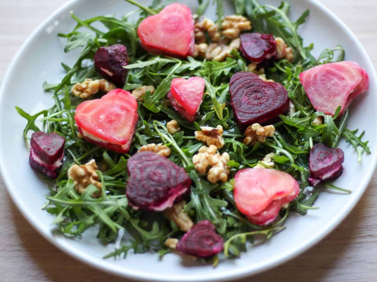 Arugula salad  topped with hear shaped beet pieces. 