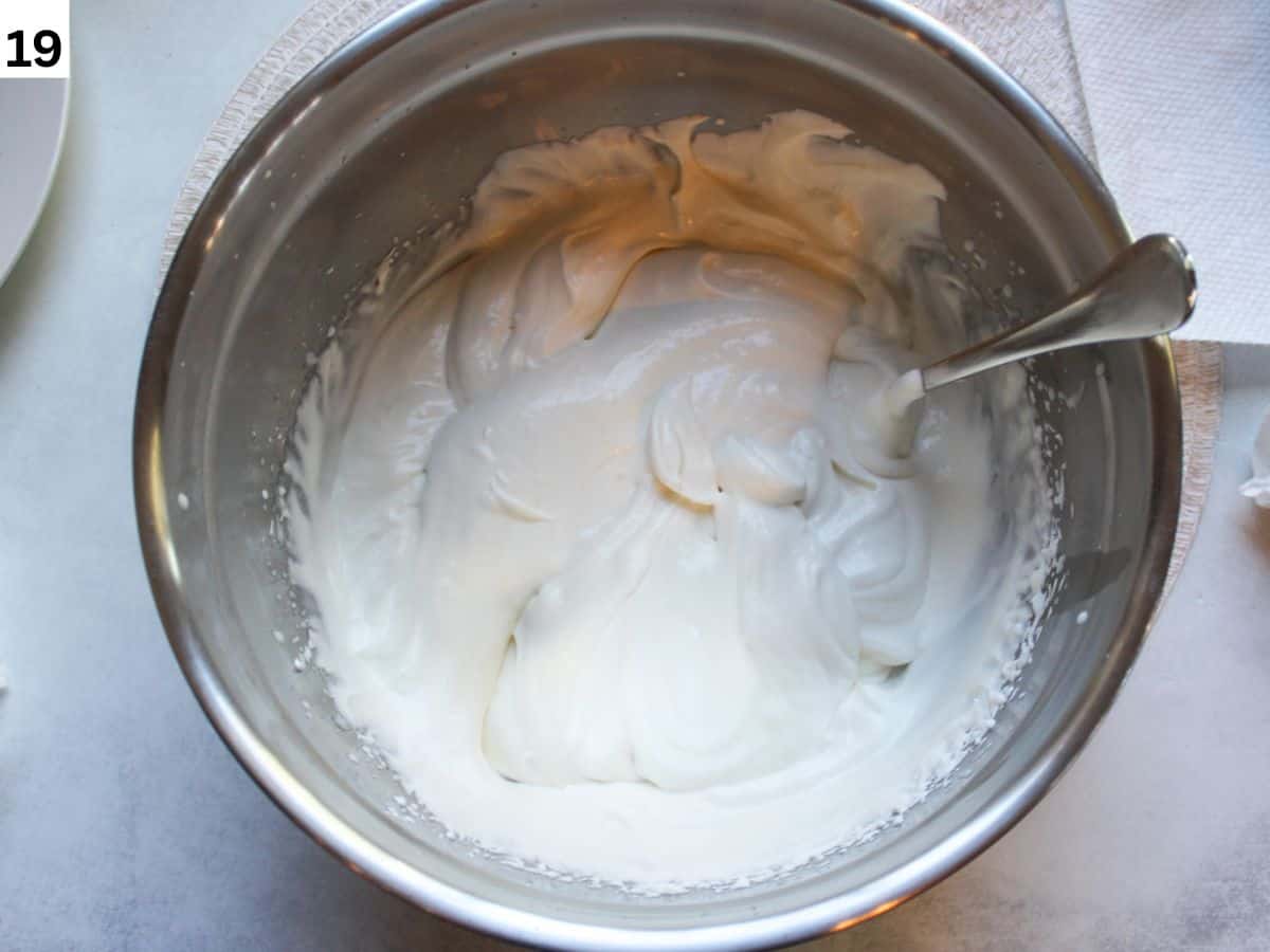 A bowl with sour cream and whipped cream frosting for honey cake. 