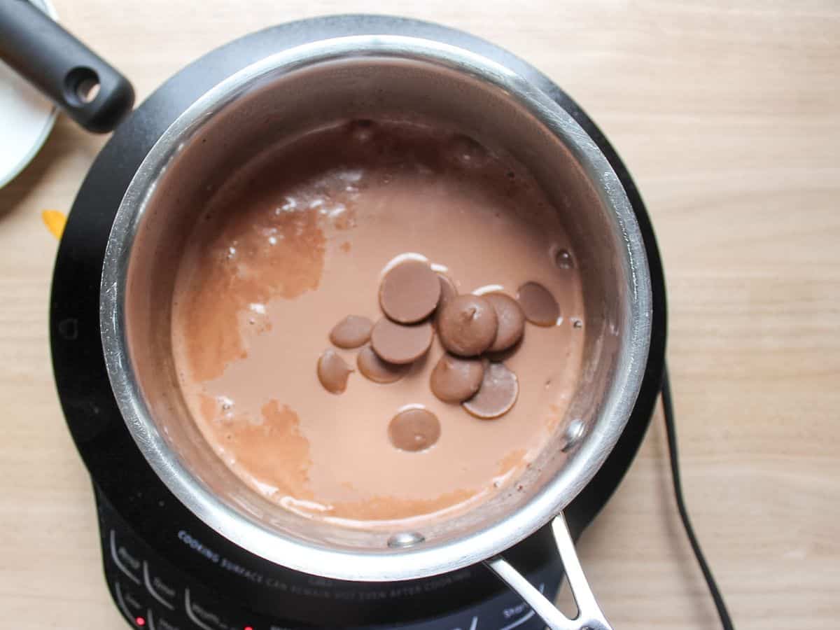 Melting real chocolate in whole milk in a saucepan.
