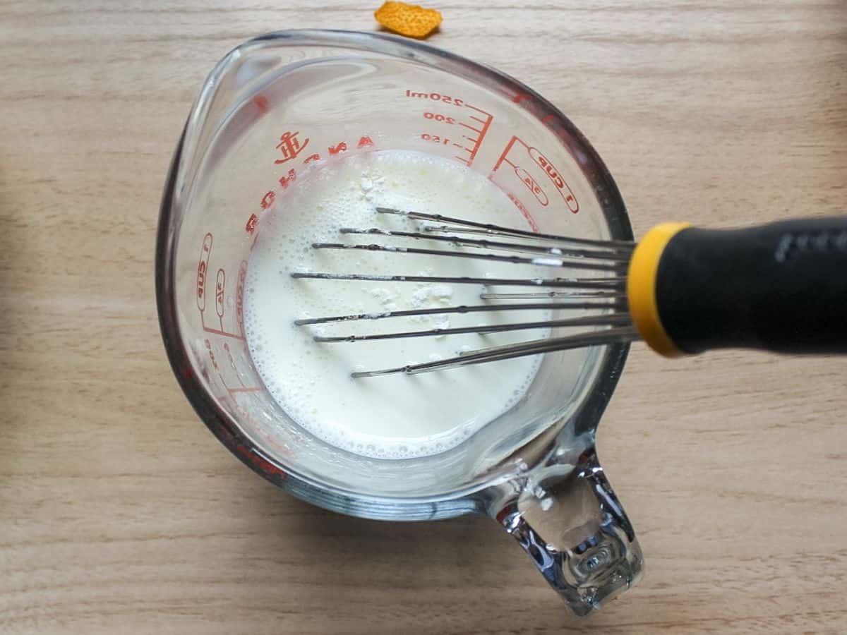 Whisking corn starch and milk in a measuring cup.