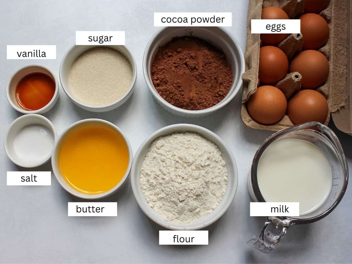 Chocolate crepes ingredients, including eggs, sugar, salt, milk, vanilla extract, flour, cocoa powder, and melted butter.