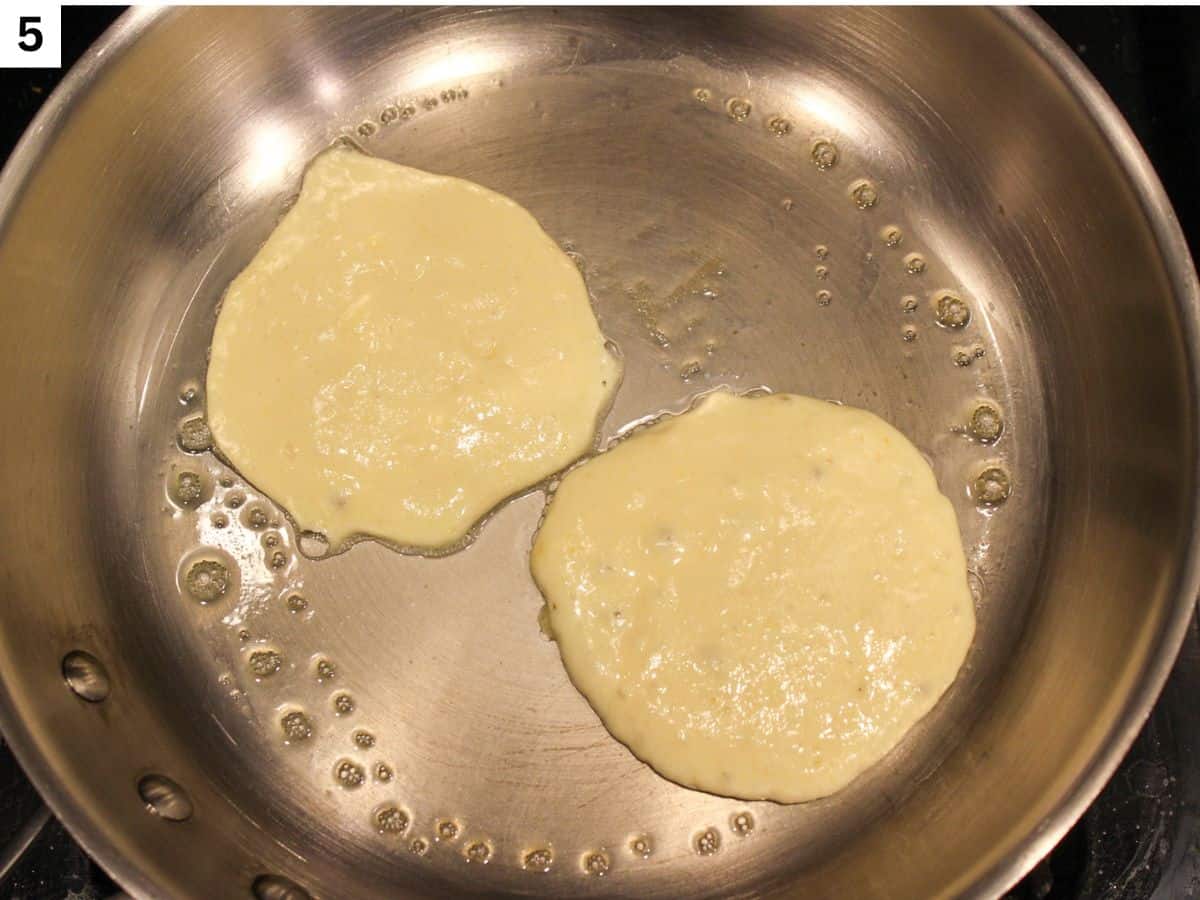 Two pancakes added to the hot skillet.