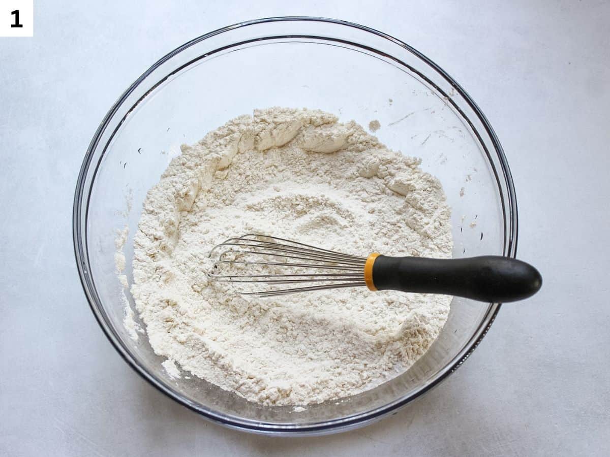 Whisking dry ingredients in a glass mixing bowl.