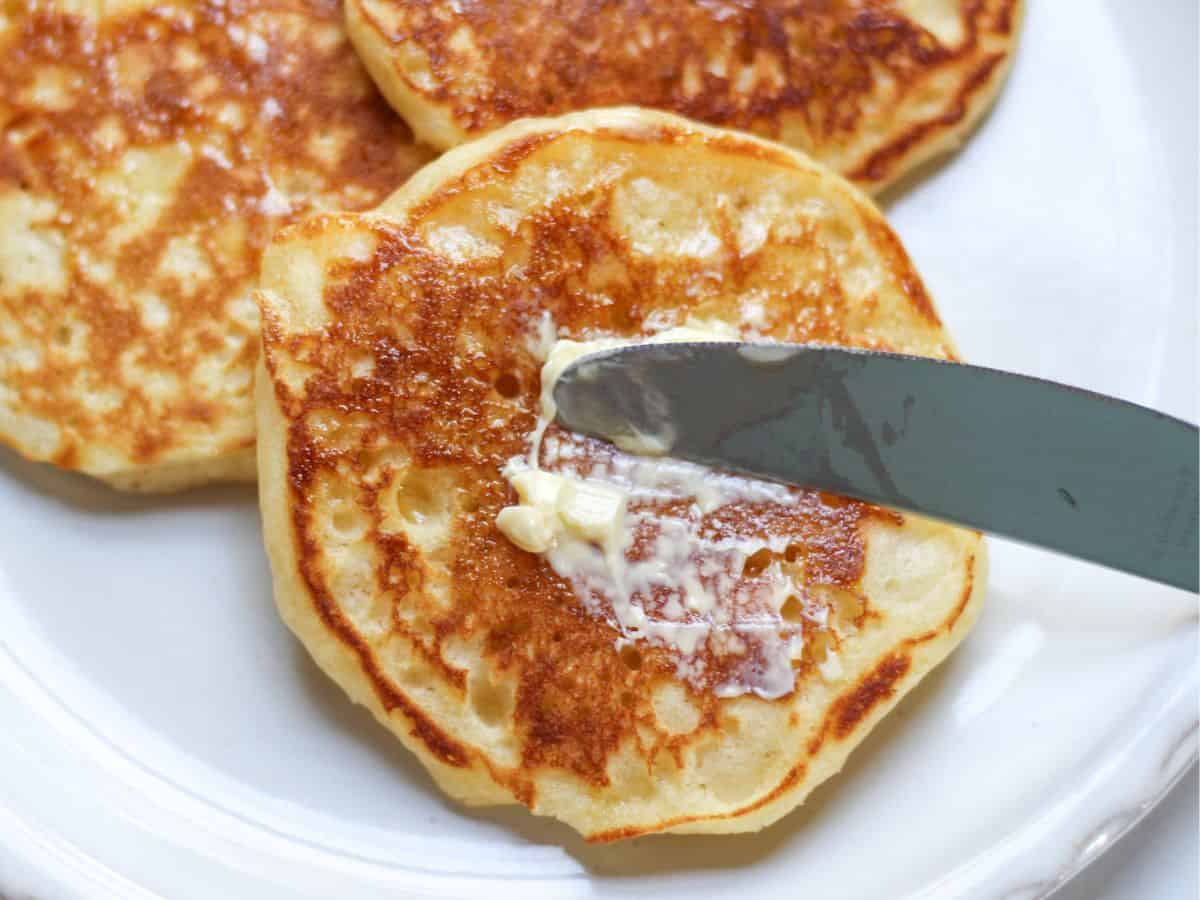 Fluffy American pancakes, served on a plate, drizzled with warm maple syrup, and spread with butter.Fluffy American pancakes, served on a plate, drizzled with warm maple syrup, and spread with butter.