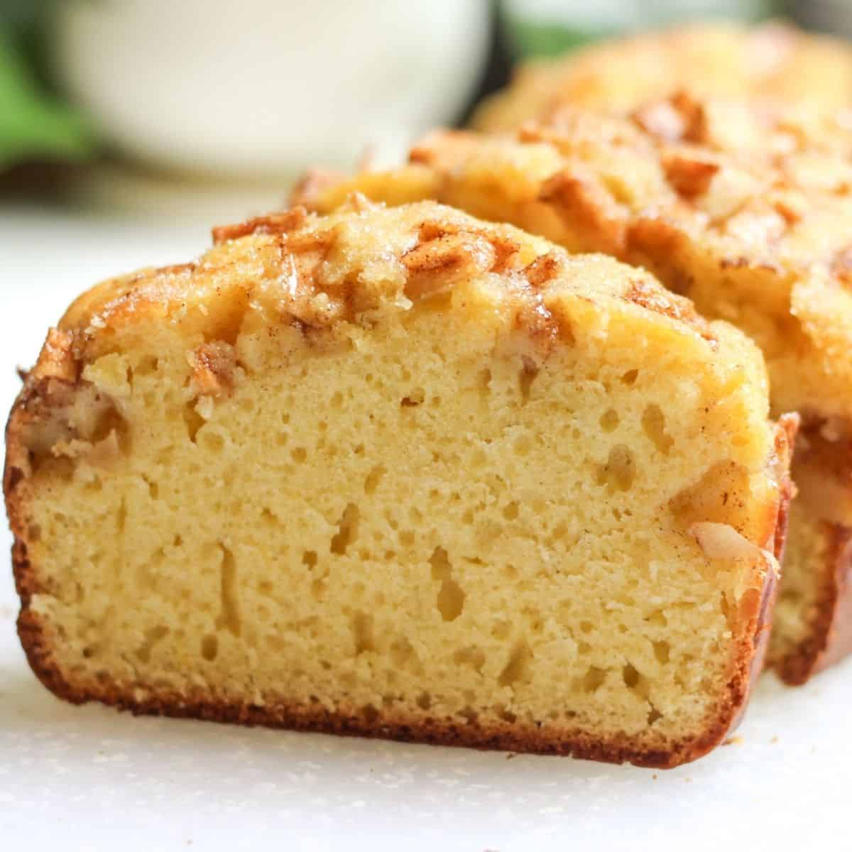 A fresh slice of homemade apple bread packed with apples.