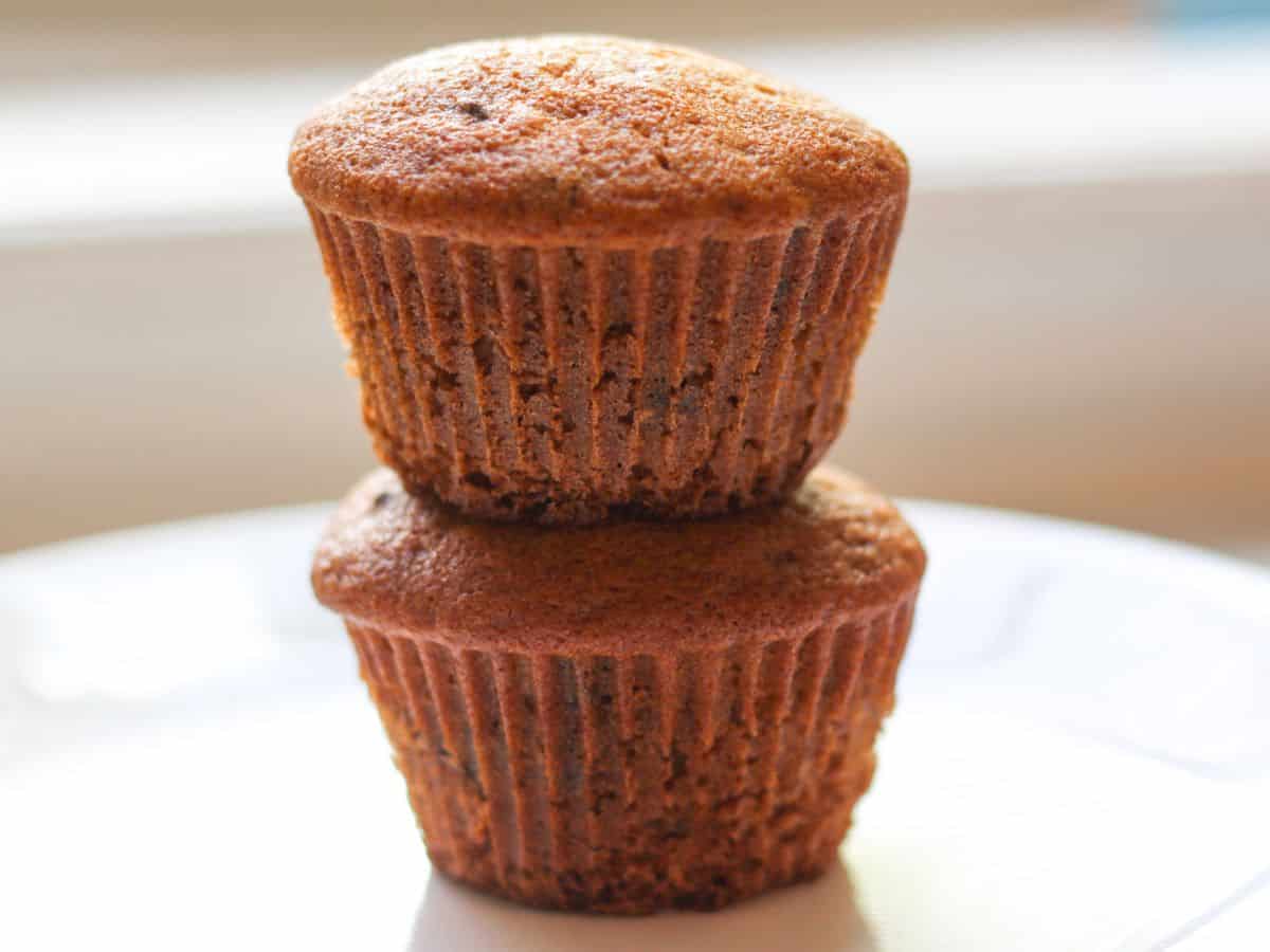 Two stacked Honey chocolate chip muffins on a plate.